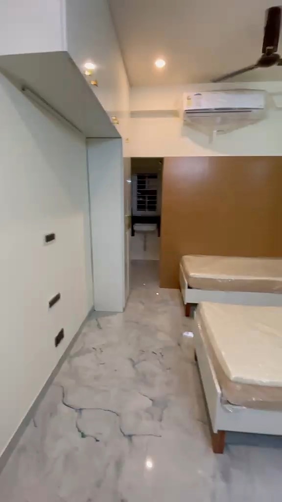 Triple sharing room — beds and storage corridor